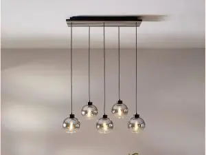 Foto van mooie hanglamp met 5 verschillende lichtbronnen boven een eettafel.