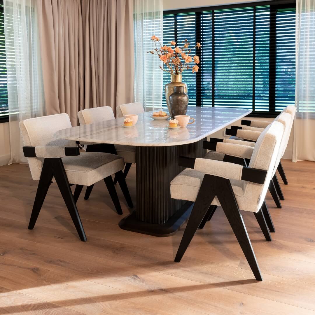 Eetkamer met moderne design eettafel, comfortabele stoelen en bloemendecor, onderdeel van de 'Cocoon Deals' voor een warme herfstuitstraling.