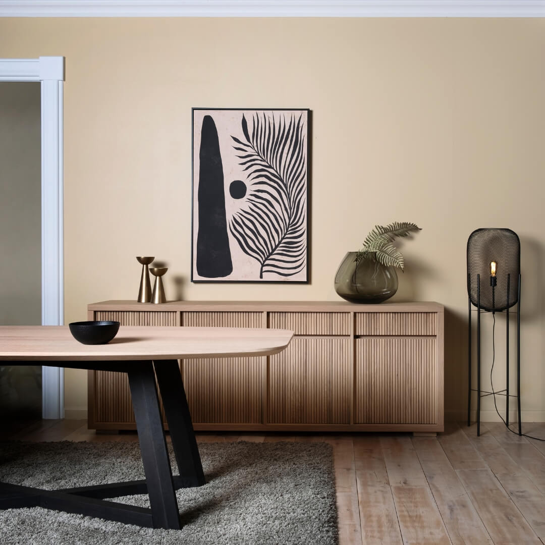 Eetkamer met licht houten dressoir, moderne kunst aan de muur, en een elegante eettafel. Een uitnodigende setting voor de herfst, gepromoot in de 'Cocoon Deals' campagne.